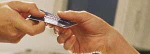 Two hands exchanging a ScotiaCard