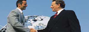 Two men shaking hands in front of a globe