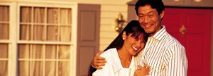 Happy couple in front of new home.