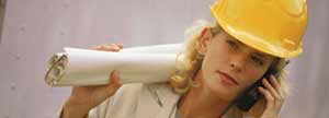 A woman in a hard hat discussing blueprints.