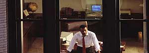 A man looking out an office window.