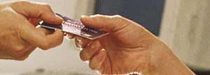A person passing a credit card to another.