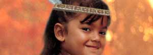 Young girl wearing a headband and feather.