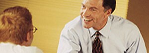 Man in shirt and tie talking to client