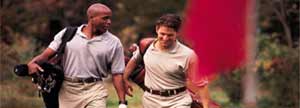 Two men carrying golf bags