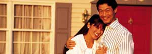 Happy couple in front of home