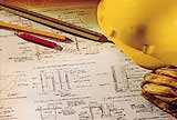 A yellow hard hat and construction plans.