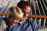 Father son on hammock with laptop