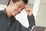 Smiling man using laptop
