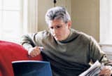 Man sitting on couch using laptop