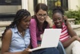 Three teens looking at laptop computer