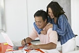 Smiling couple working at laptop