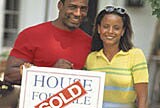 Couple in front of their new home.