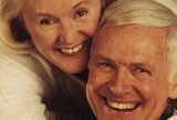 Smiling retired couple hugging