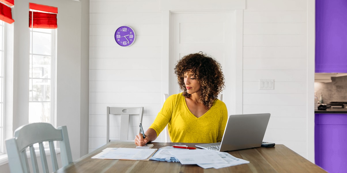 Woman sitting at table on laptop.