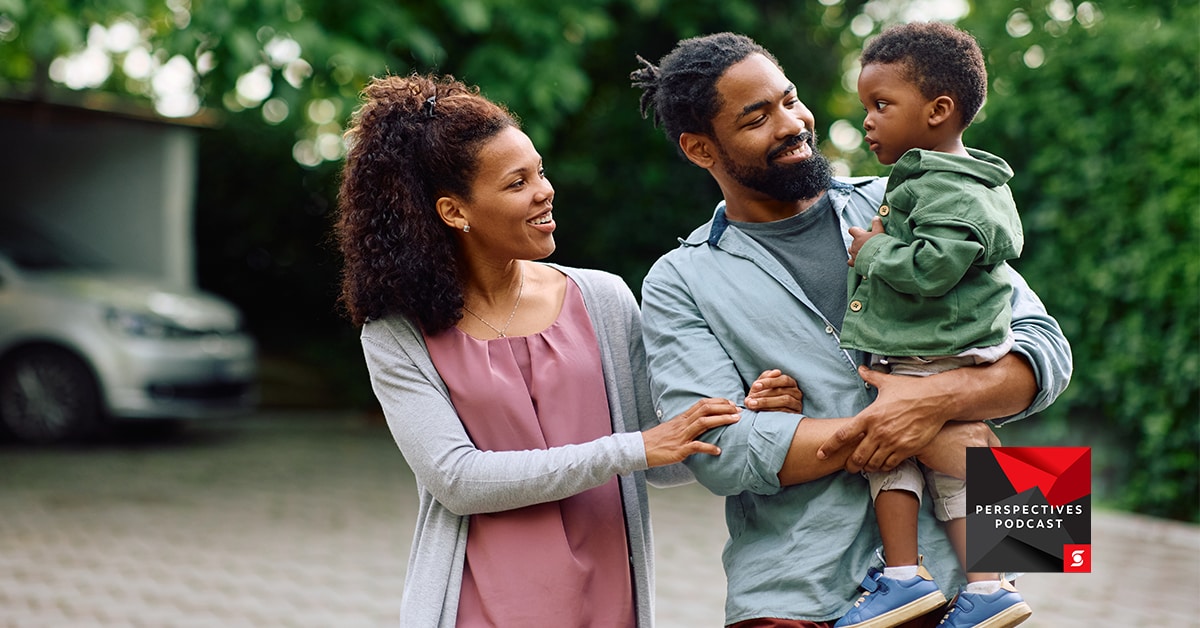 Parents carrying child outdoors