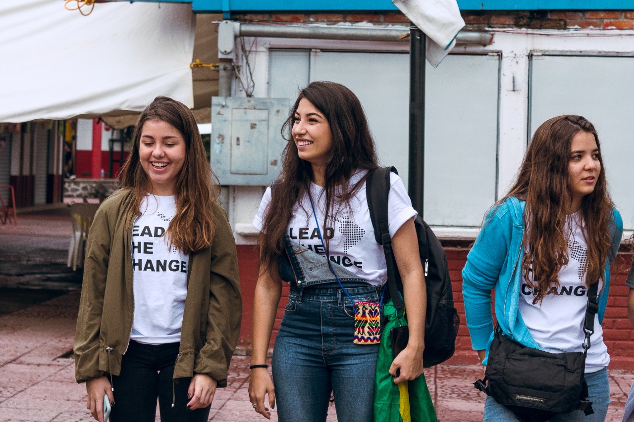 Three girls outside with shirts that read "Lead the change"