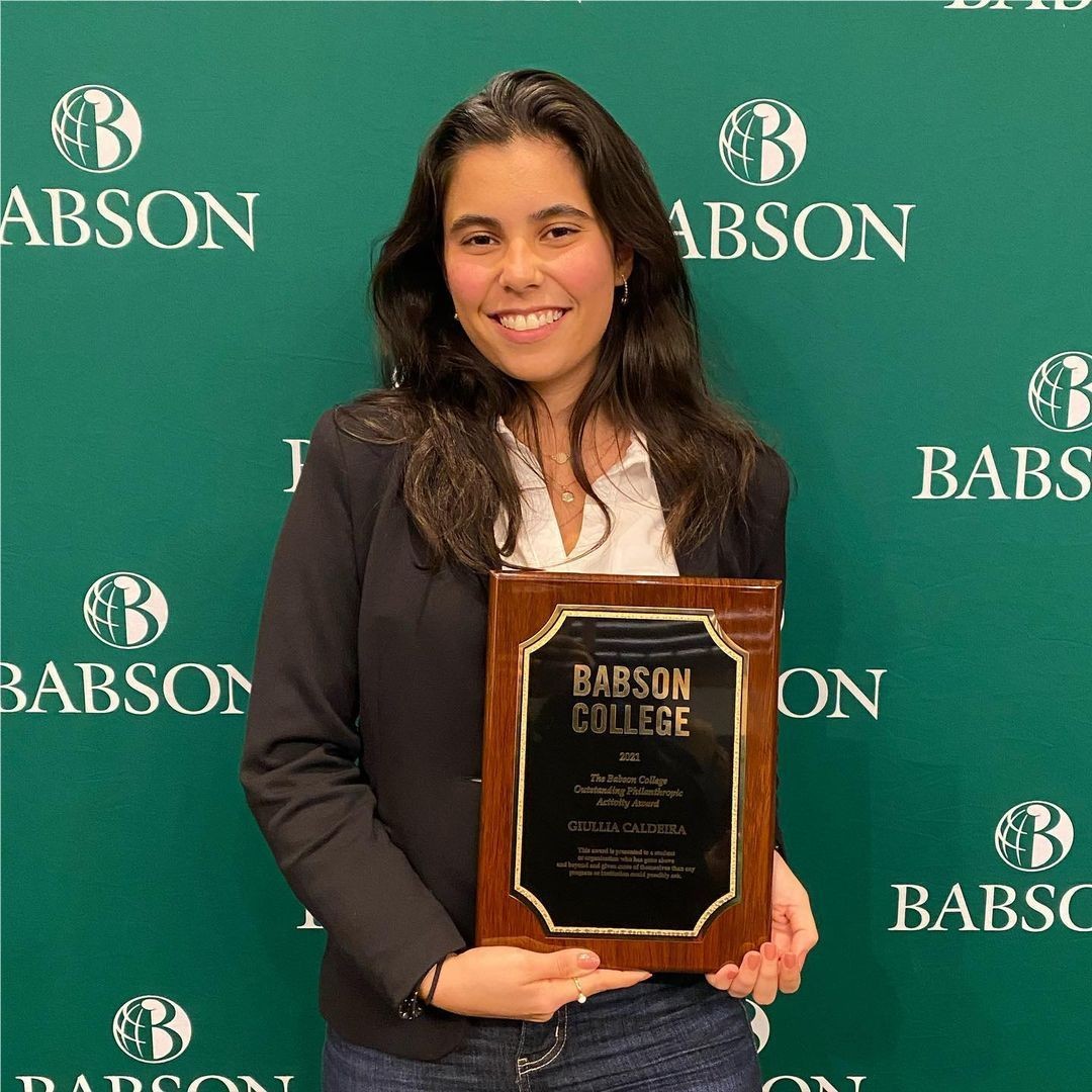 Giullia Jacques posing with plaque award from Babson College
